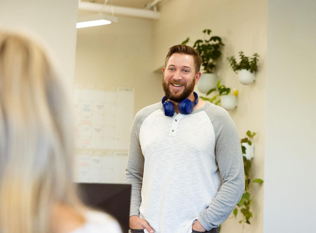 Man with headphones in a casual office conversation at Granite City Workspaces